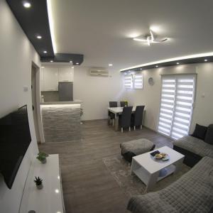 Apartman Amor Trebinje في تريبينيي: غرفة معيشة مع أريكة وطاولة