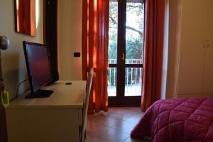 a bedroom with a desk with a computer and a window at Hotel Il boschetto in Tolentino