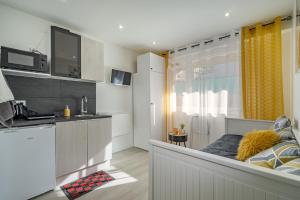 małą kuchnię z kanapą w pokoju w obiekcie Plage Catalans:Studio entre la mer & le Parc Pharo w Marsylii