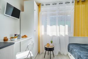 mała sypialnia z łóżkiem i oknem w obiekcie Plage Catalans:Studio entre la mer & le Parc Pharo w Marsylii