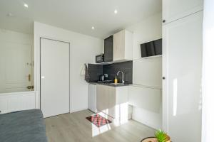 Biała kuchnia ze zlewem i blatem w obiekcie Plage Catalans:Studio entre la mer & le Parc Pharo w Marsylii +3 zdjęcia