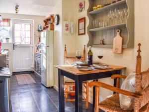 a kitchen with a table and two glasses of wine at Pan Cottage in Middleton
