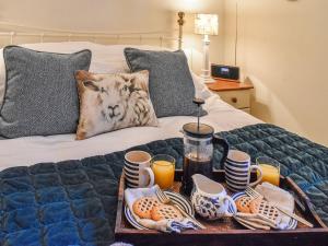 a tray with food and drinks on a bed at Pan Cottage in Middleton