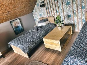 1 dormitorio con cama y mesa de madera en Wzgórza Kunowskie - domy na wynajem z basenem, baliami i saunami, en Bodzentyn