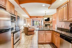 a kitchen with wooden cabinets and a living room at Chula Vista Condo Unit 2645 in Wisconsin Dells