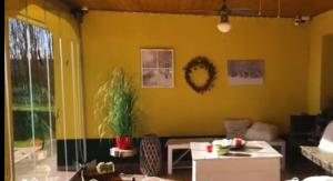 uma sala de estar com uma parede amarela em Sunshine Tanya em Nagykőrös