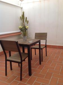 a wooden table and two chairs with flowers on it at Hotel Madanis Liceo in Hospitalet de Llobregat