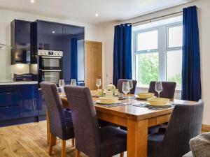 a kitchen and dining room with a wooden table and chairs at Druids Knowe in Tarfside