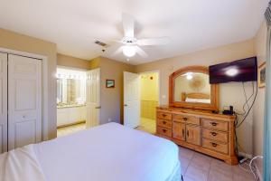 een slaapkamer met een bed, een dressoir en een spiegel bij Grand Caribbean West 0107 in Perdido Key