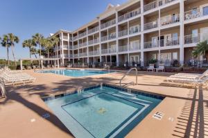 a resort with a swimming pool and chairs and a building at Grand Caribbean West 0107 in Perdido Key