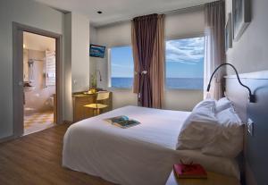 a hotel room with a bed and a view of the ocean at Hotel La Baia in Diano Marina