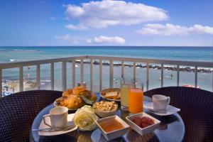 a table with food and a view of the beach at Hotel La Baia in Diano Marina