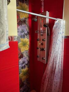um chuveiro na casa de banho com uma parede vermelha em Apartamento El Colmao em Chipiona