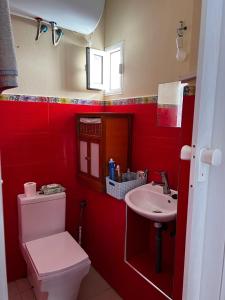 uma casa de banho vermelha com um WC e um lavatório em Apartamento El Colmao em Chipiona