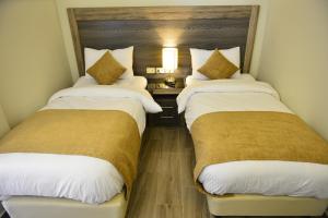 dos camas sentadas una al lado de la otra en una habitación en Moses Residence en Wadi Musa