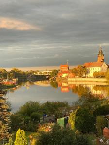 vistas a un río con edificios y un puente en Pension Zur Alten Post, en Havelberg