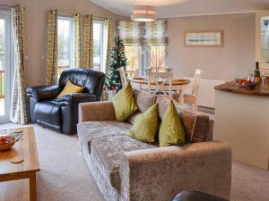 a living room with a couch and a dining room at Lakeside in Kelsale