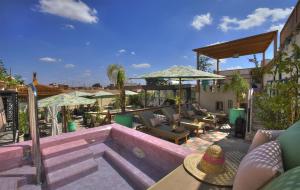 a patio with chairs and tables and umbrellas at Riad Dar Fanny in Marrakesh