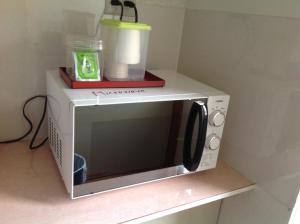 a microwave oven with a cup on top of it at Pension New White Bear in Kutchan