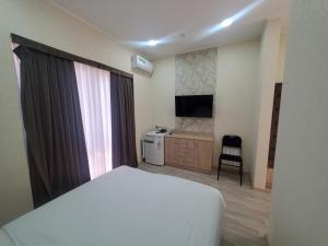 a bedroom with a bed and a desk and a television at MAZZA Hotel in Tashkent