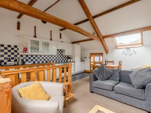 a living room with a couch and a kitchen at Robins Nest - Uk36208 in Llanfihangel-y-creuddyn