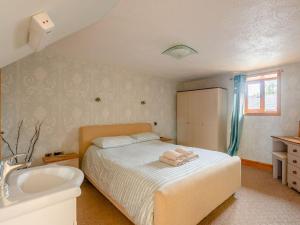 1 dormitorio con cama, lavabo y bañera en Robins Nest - Uk36208, en Llanfihangel-y-creuddyn