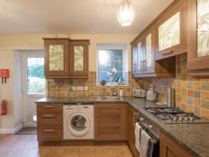 a kitchen with a washer and a washing machine at The Coach House in Oswestry