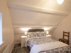 een slaapkamer met een bed en een stoel bij The Coach House in Oswestry