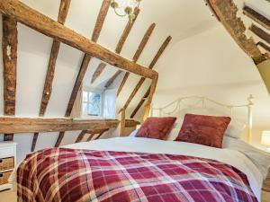 a bed in a room with wooden beams at The Cottage in Warborough