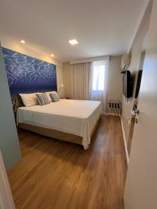 1 dormitorio con 1 cama con pared azul en Top Flat Fortaleza, en Fortaleza