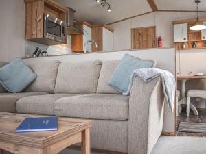 ein Wohnzimmer mit einem Sofa und einem Tisch in der Unterkunft Everard - Uk37772 in Stoupe Brow