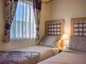 1 Schlafzimmer mit 2 Betten und einem Fenster in der Unterkunft Everard - Uk37772 in Stoupe Brow