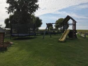 un parque infantil con un tobogán en un patio en Schlafkota vom Friesenhof Wieratal 