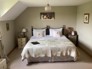 ein Schlafzimmer mit einem Bett mit einer weißen Bettdecke und Kissen in der Unterkunft Bosvean House Bed & Breakfast in Bude