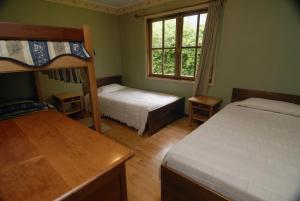 Un dormitorio con dos literas y una ventana. en Mavidahue, en llifen