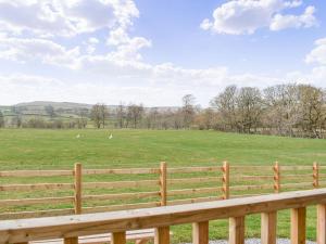 a wooden fence with a field in the background at The Elm Uk38290 in Crosby Garrett