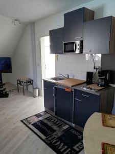 - une cuisine avec des placards bleus et un tapis de cuisine au sol dans l'établissement Ferienwohnung 313-1-R Stübchen, à Neddesitz