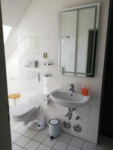 La salle de bains blanche est pourvue d'un lavabo et de toilettes. dans l'établissement Ferienwohnung 313-1-R Stübchen, à Neddesitz