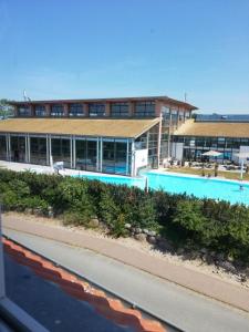 a building with a swimming pool next to a road at Ferienwohnung 313-1-R Stübchen in Neddesitz