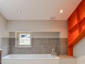 a bath tub in a bathroom with a window at Larch Cottage - Uk36198 in Fordingbridge
