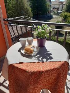 a table with two cups and a plate of food at Appartamento Sophia in Collegno