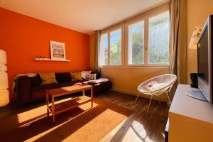 sala de estar con paredes de color naranja y sofá en Beautiful 1950s style apartment close to the city center en Tours