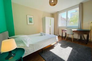 1 dormitorio con cama, escritorio y ventana en Beautiful 1950s style apartment close to the city center en Tours