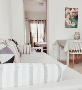 a white living room with a couch and a table at Yanna's Apartments in Sidari