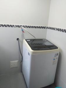 a washing machine in a corner of a room at Apart Hotel Cabral in Lima