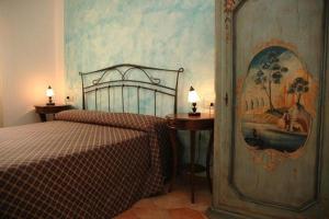 インペリアにあるIl tempo di Zia Palmira - AGRITURISMO IL RISVEGLIOのベッドルーム1室(ベッド1台付)が備わります。壁には絵画が飾られています。