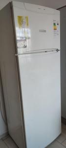 a white refrigerator freezer sitting next to a wall at Şirinevler 304 in Istanbul