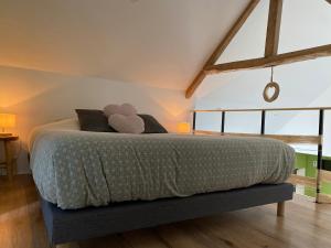 Un dormitorio con una cama con un osito de peluche. en La Suite Chambre d’hôtes Spa et Sauna, en Aire-sur-la-Lys