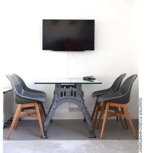 a table with two chairs and a tv on top at Dunster Studio Apartment in Dunster
