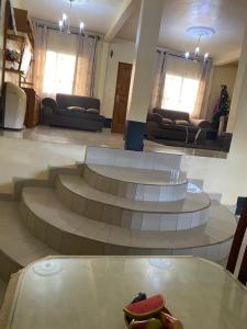 Zimmer mit Treppe und Tisch mit Skateboard drauf in der Unterkunft Apex guest facility in Buea